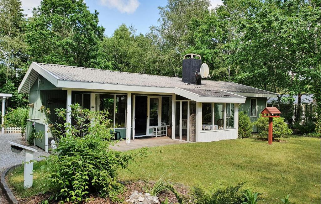 a small green house with a large porch and aestead at Gorgeous Home In Ansager With Wifi in Ansager