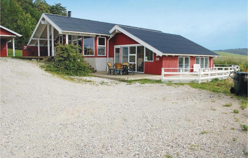 una casa roja con una mesa y sillas frente a ella en Nice Home In Knebel With Indoor Swimming Pool en Skødshoved Strand