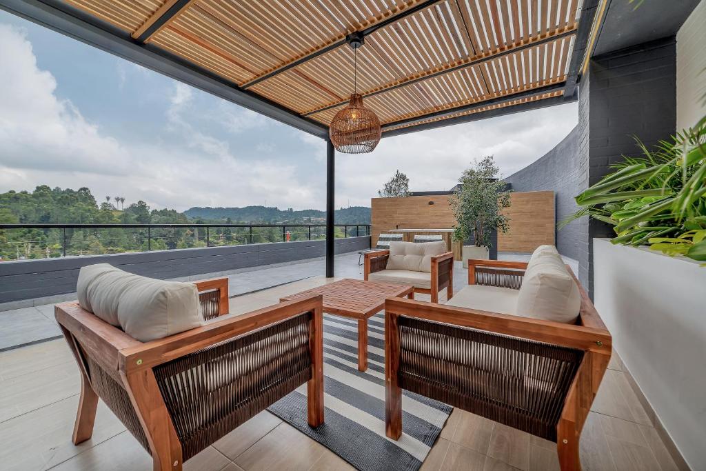 un patio avec des chaises et une table sur une terrasse dans l'établissement Olive Living Suites by HOUSY HOST, à Envigado
