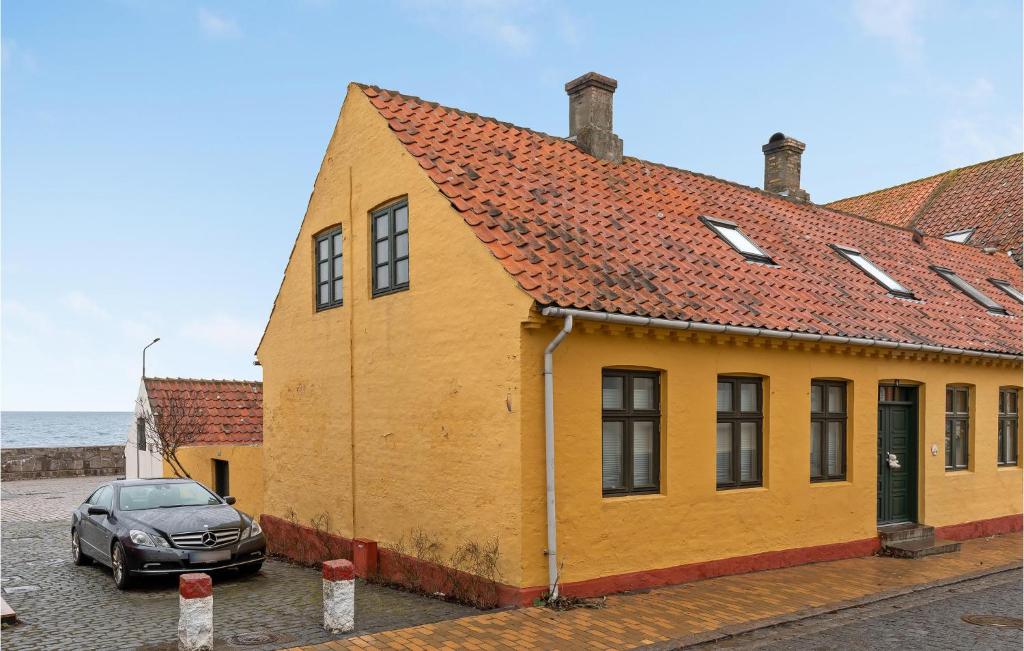 a yellow building with a car parked in front of it at Stunning Home In Allinge With Kitchen in Allinge