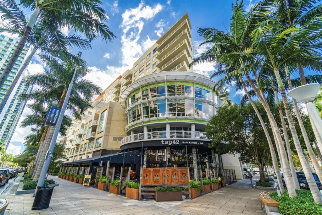 um edifício com palmeiras em frente em Platinum 2BD 2BTH at Midblock em Miami