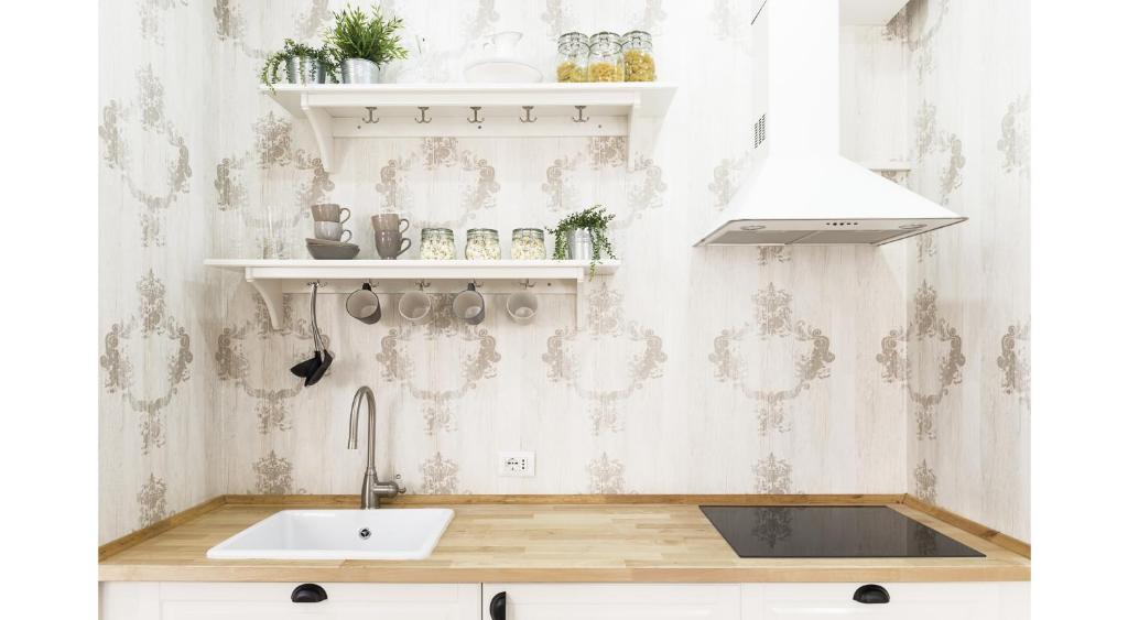 a kitchen with a sink and a wall at St. Peter Sweets in Rome