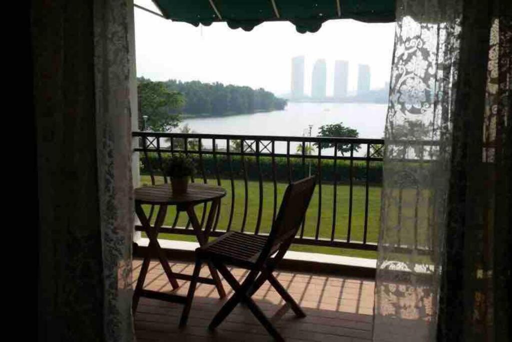 um pátio com uma mesa e uma cadeira na varanda em Romantic Suite by the Lake em Cyberjaya