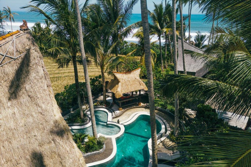 an aerial view of a resort swimming pool with palm trees at Most Exotic Villa Keong Tabanan in Tabanan