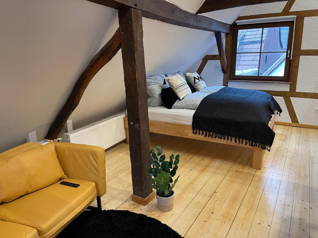 a bedroom with a bed and a chair in a attic at Hideaway im Odenwald nahe Heidelberg in Eberbach