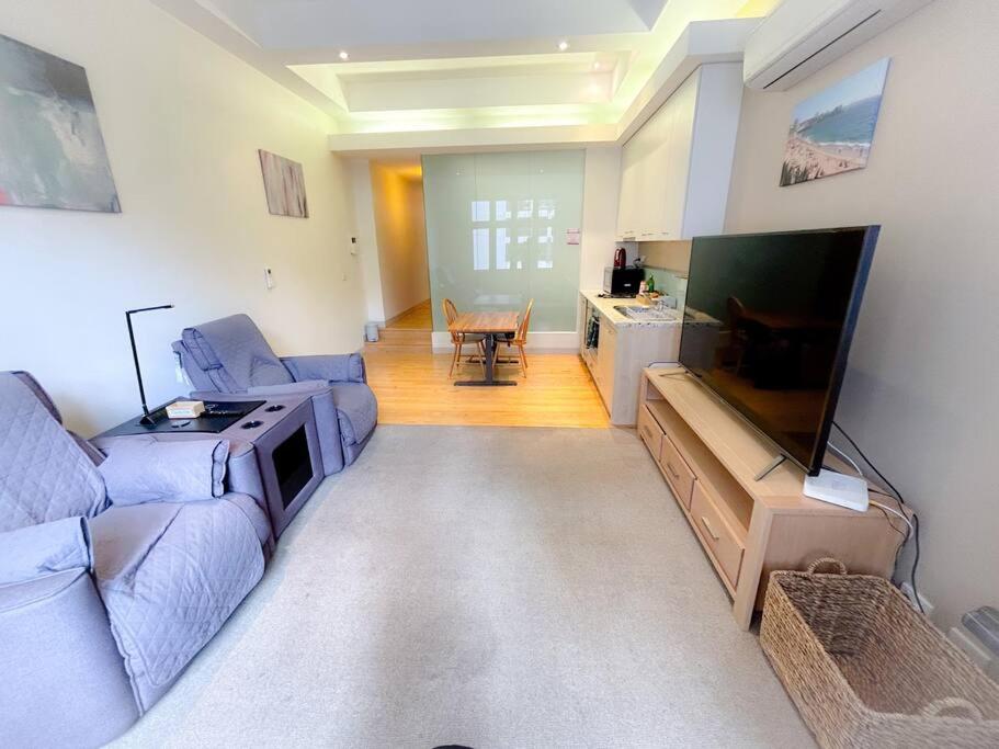 sala de estar con sofá y TV de pantalla plana en Melbourne City Central Apartment - 296 en Melbourne