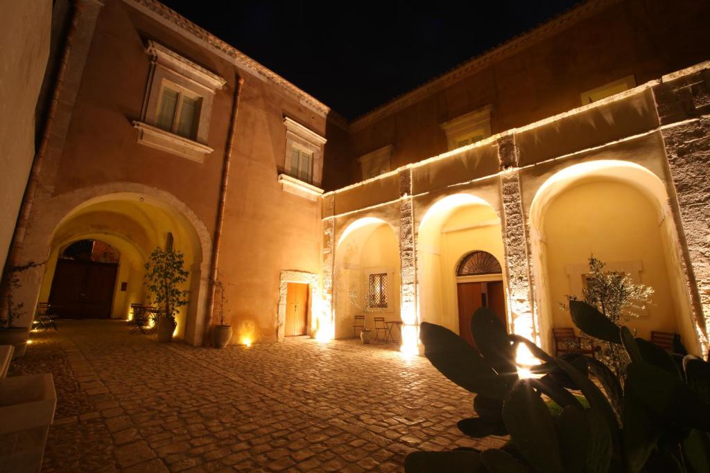 an empty courtyard of a building at night at Palazzo Gambuzza in Ispica