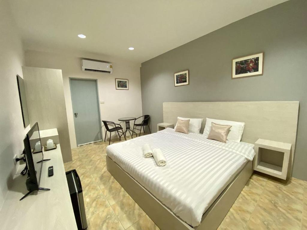 1 dormitorio con 1 cama y escritorio con TV en บ้านสายสิริ, en Ban Bang Talat
