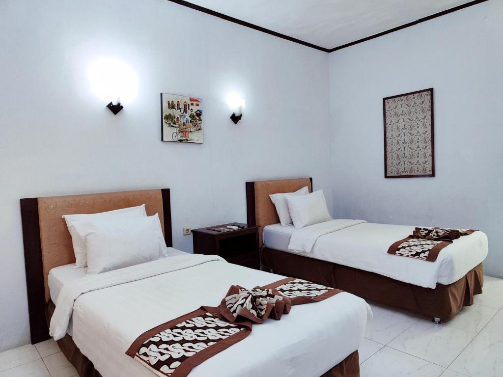 Postel nebo postele na pokoji v ubytování Paku Mas Hotel