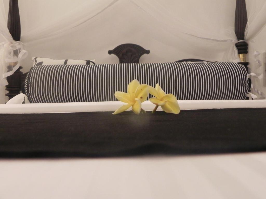 two yellow flowers sitting on top of a bed at Amanda Beach Villas in Unawatuna