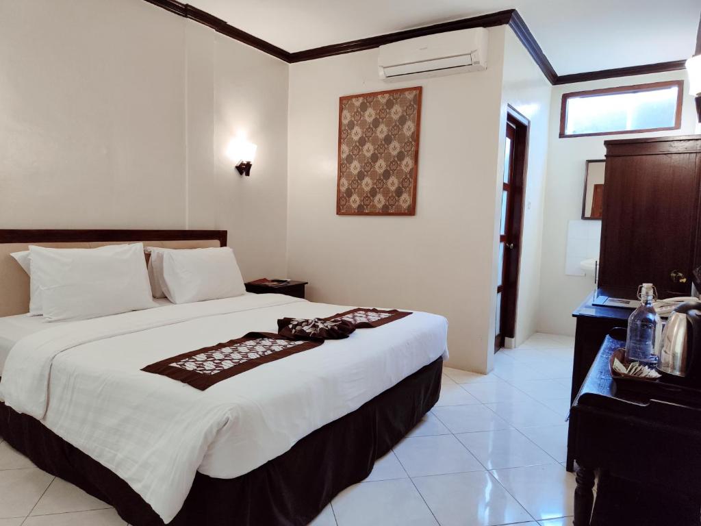 Postel nebo postele na pokoji v ubytování Paku Mas Hotel