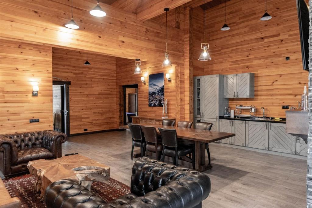 a dining room with a table and leather chairs at Le Chalet by Amirsoy in Chimgan