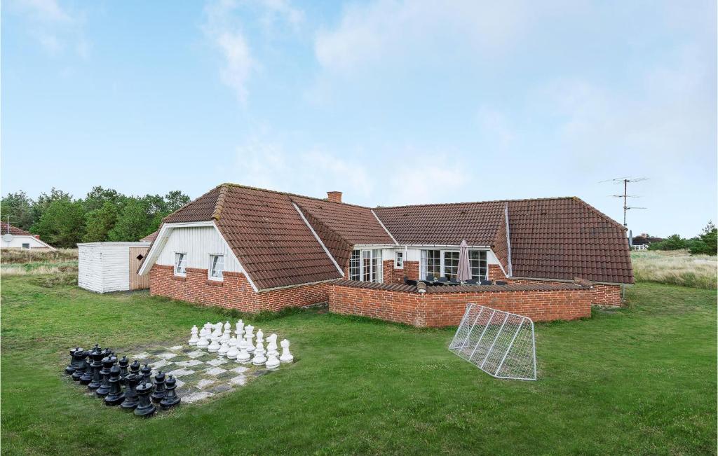 una casa con un partido de fútbol delante en Amazing Home In Fan With Sauna, Wifi And Indoor Swimming Pool, en Sønderho