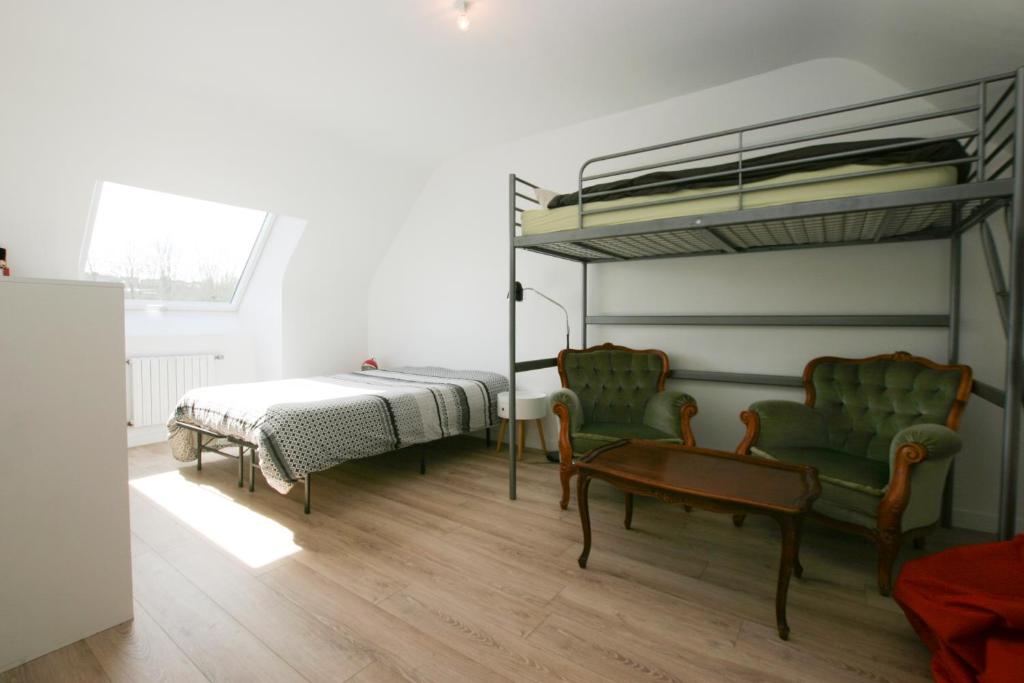 a bedroom with a bunk bed and two chairs at La " Villa " du JET in Ergué-Gabéric