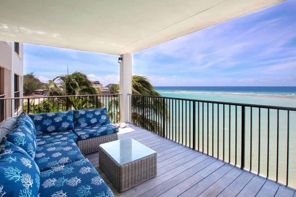 a couch on a balcony with a view of the ocean at Beachfront Luxury with Incredible Ocean Views apts in Christ Church