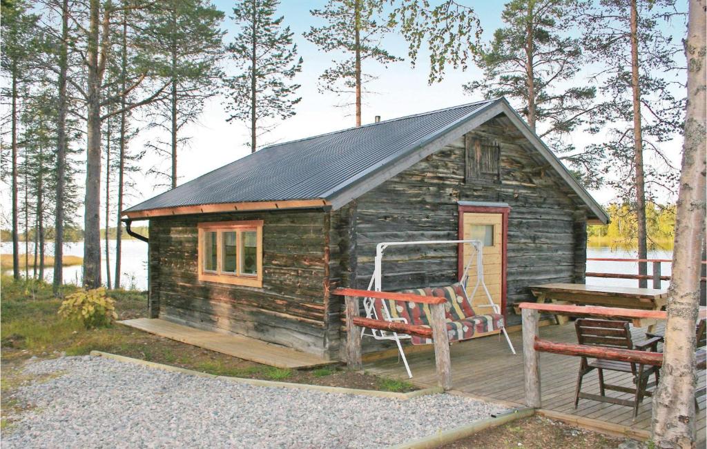 a small log cabin with a chair and a bench at Amazing Home In Arvidsjaur With Sauna in Lomträsk