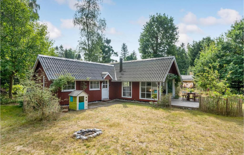 een rood huis met een tuin bij Beach Front Home In Strby With Kitchen in Strøby