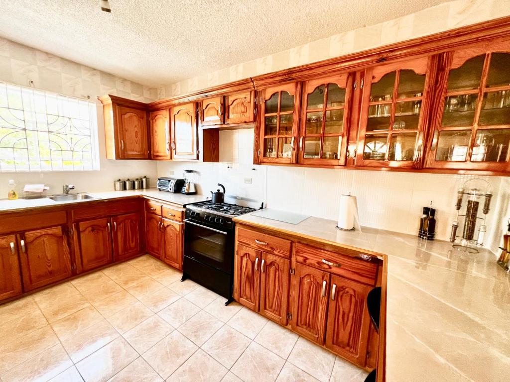 a kitchen with wooden cabinets and a black stove at 2 Bed Apartment at the Hideaway in St Mary