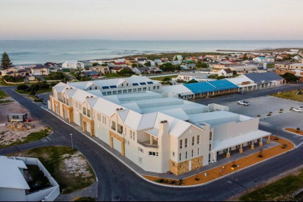an aerial view of a large white building next to the ocean at Unit 8 Alwil Ocean View Villa in Struisbaai