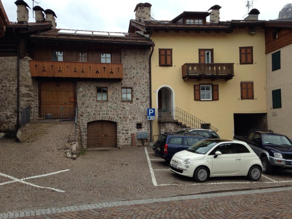 a white car parked in a parking lot in front of a building at Ciasa Bocter in Moena