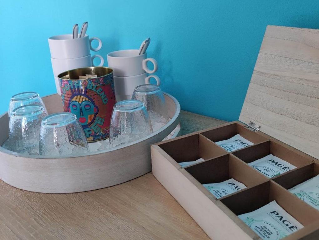 two boxes with glasses and a cup on a table at Chambres d'hôtes Tontouta Tamoa in Païta