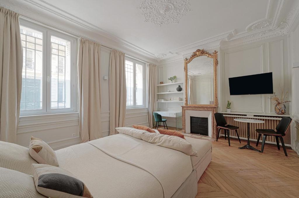 uma sala de estar com um sofá, uma televisão e uma mesa em Studio Quartier Champs Elysées 1 em Paris