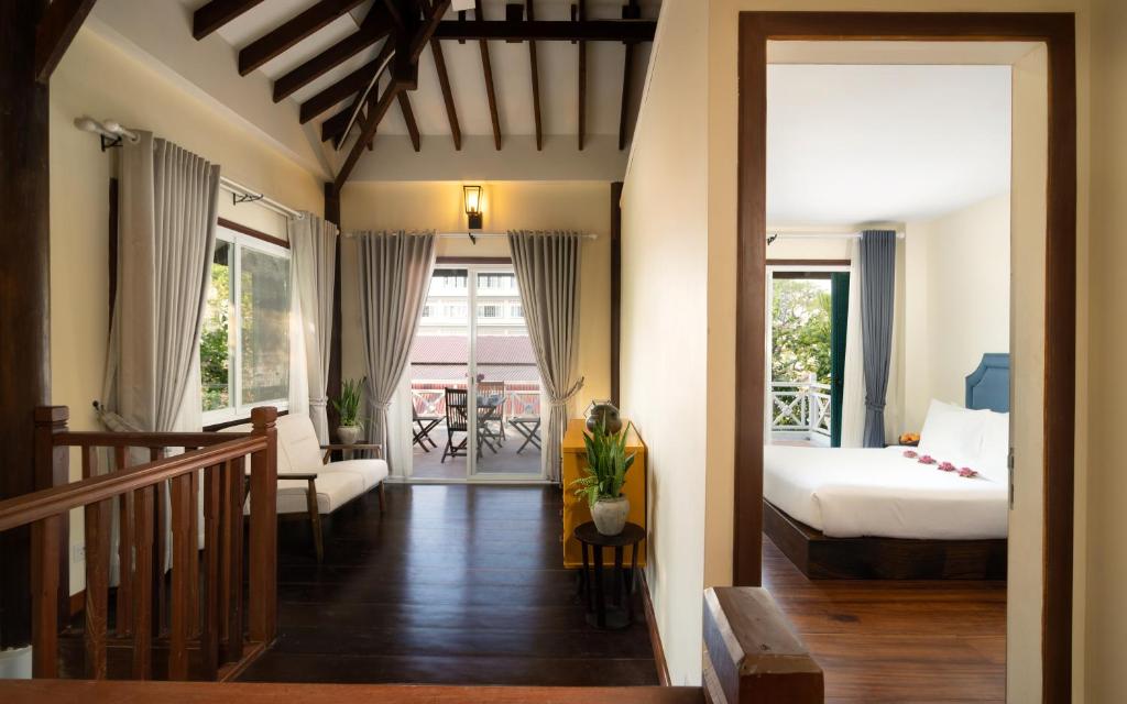 a hotel room with a bed and a balcony at The Elephant in Siem Reap