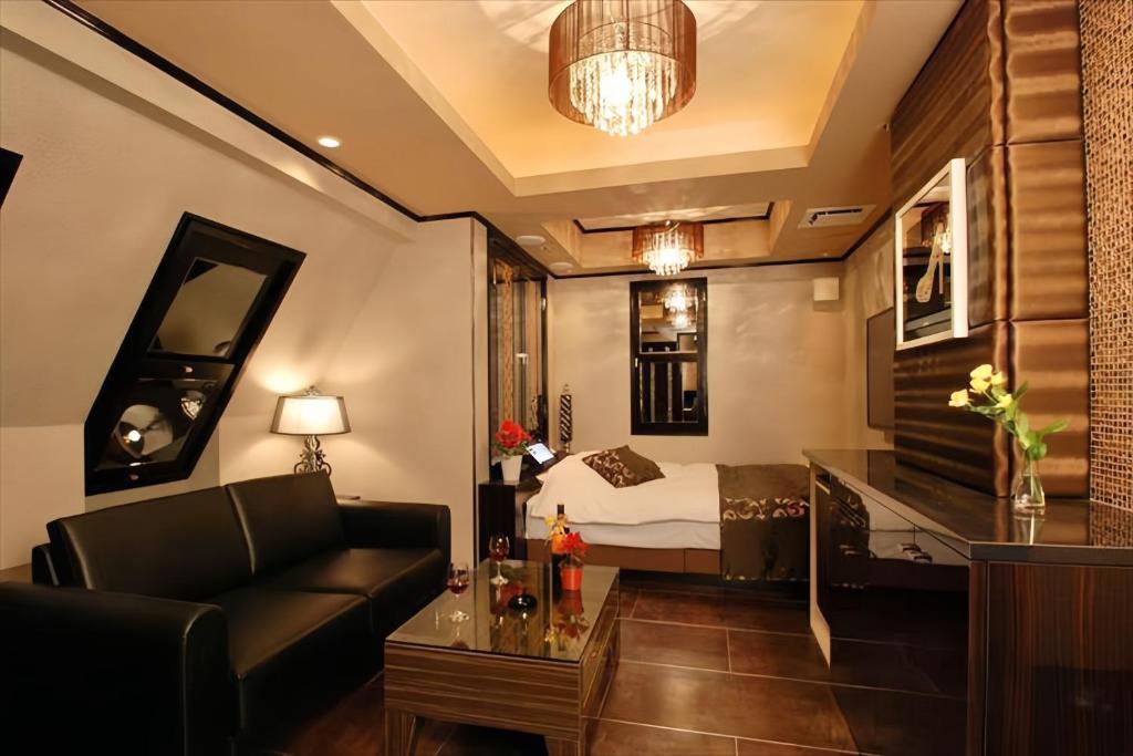 un soggiorno con divano e un letto in una camera di HOTEL Shuffle a Tokyo