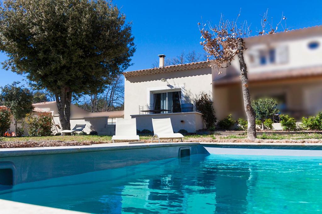 a swimming pool in front of a house at Le JARDIN DES DELIS gite NEUF avec piscine bio UV in Saint-Saturnin-les-Apt