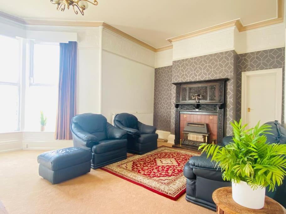 a living room with blue chairs and a fireplace at Spacious Flat In a Victorian House - Free Parking in Bradford