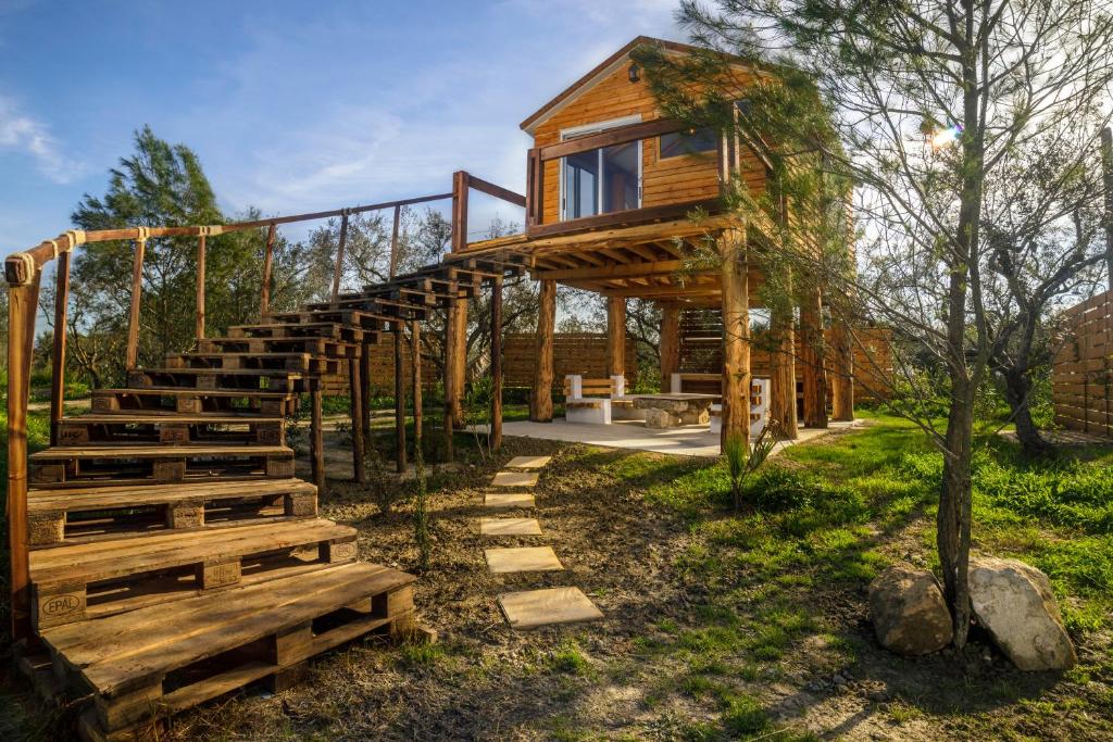 Un escalier en bois mène à une cabane dans les arbres. dans l'établissement Green Leaf, à Vanáton