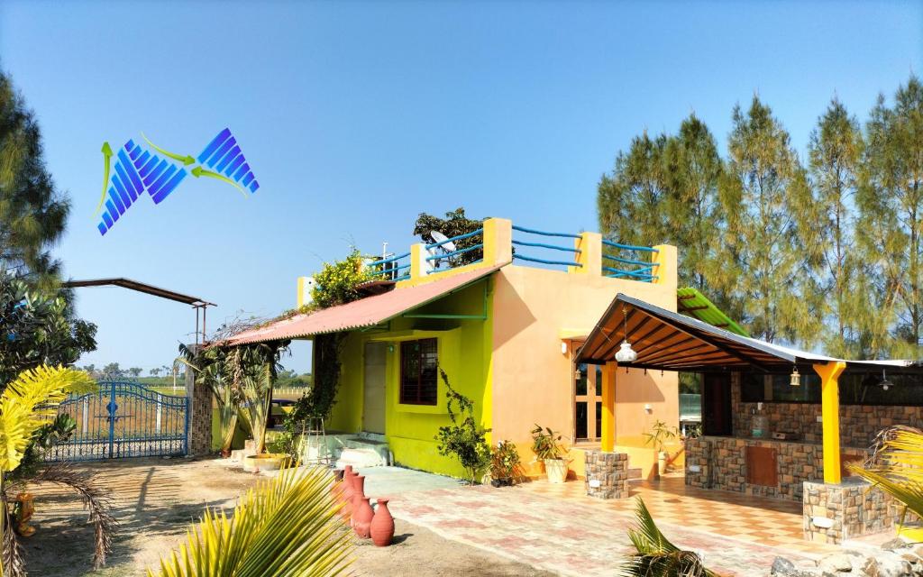 una casa con una cometa volando en el cielo en CoralbayFarms en Chengalpattu