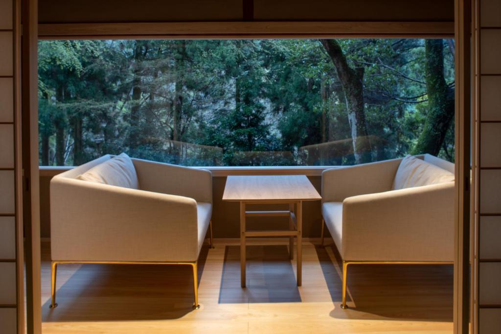 a room with two chairs and a table in front of a window at Tsukihitei in Nara