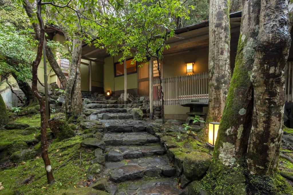 a stone path leading to a house with trees at Tsukihitei in Nara