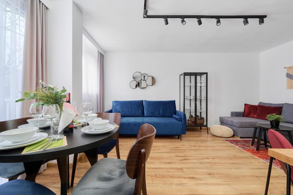 ein Wohnzimmer mit einem Tisch und einem blauen Sofa in der Unterkunft Wrocław City Centre & Main Square Apartment by Renters in Breslau