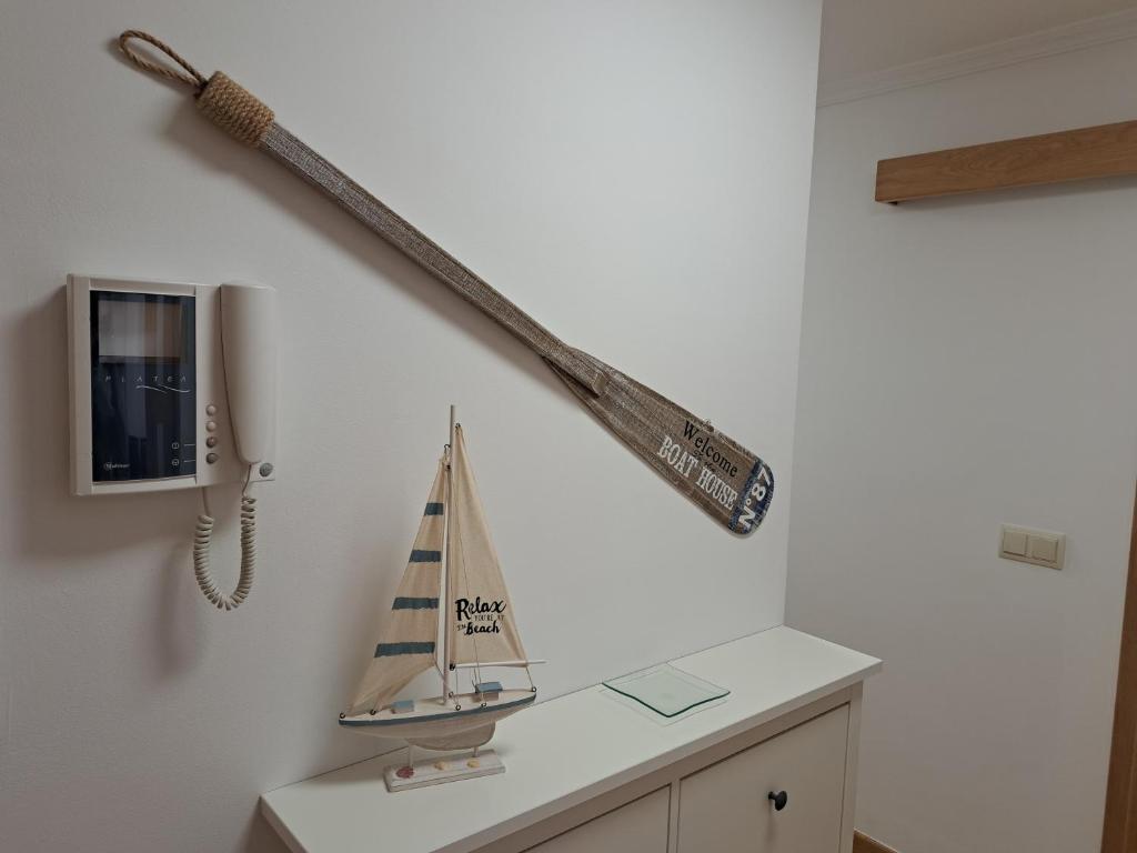 ein Regal mit einem Spielzeug-Segelboot an der Wand in der Unterkunft APARTAMENTO GUIMAREY in Sanxenxo