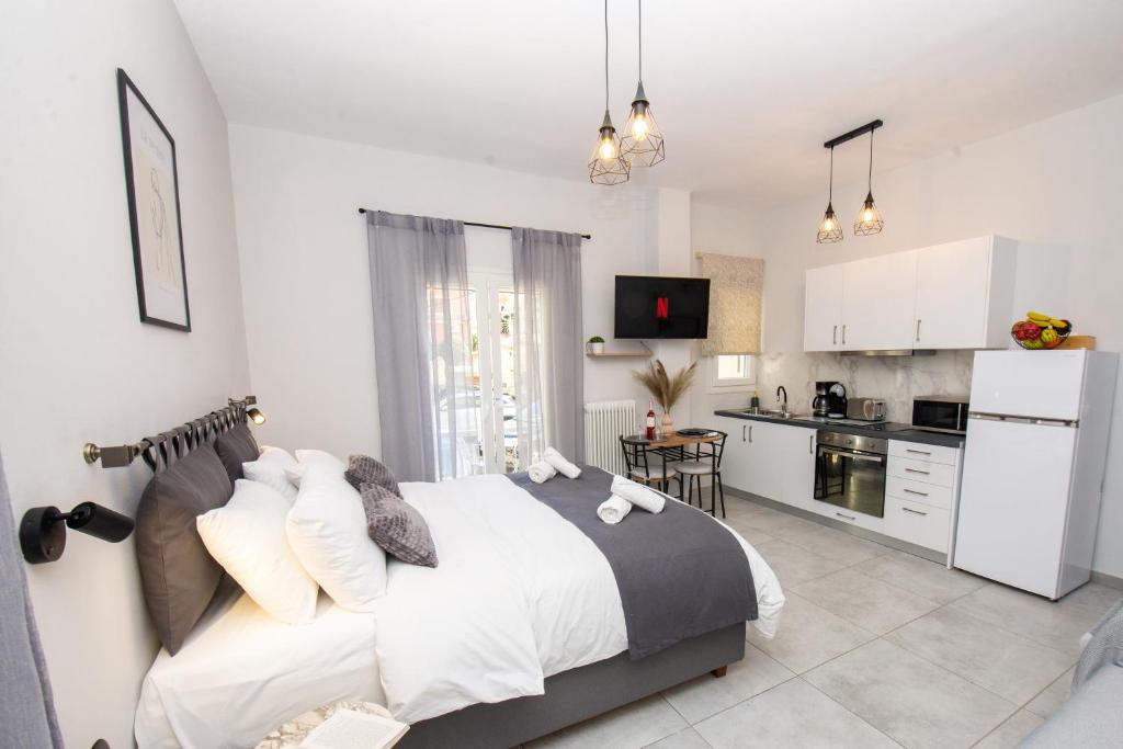 a bedroom with a large bed and a kitchen at Celestina Corfu Town Apartment in Corfu