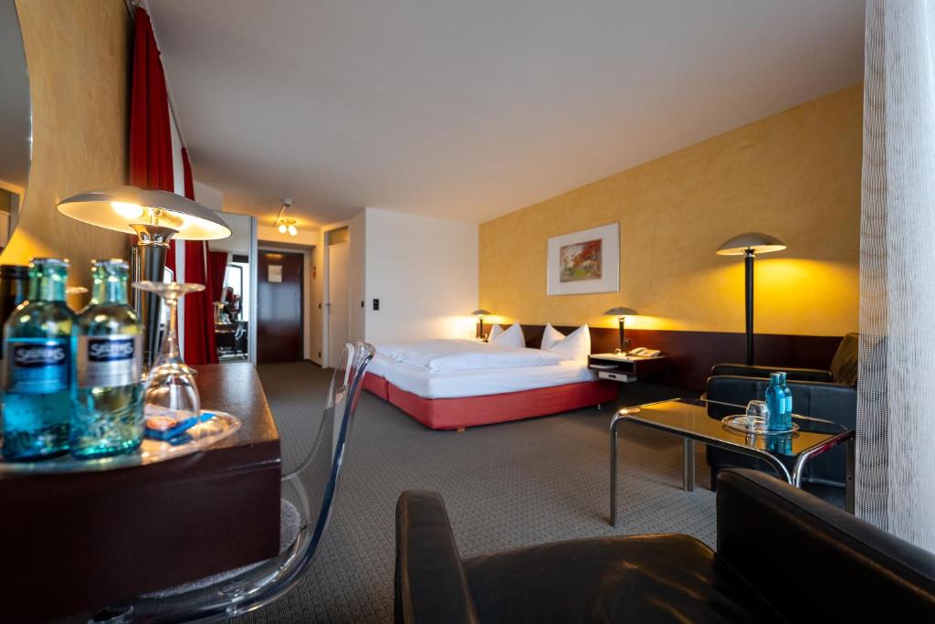 ヴェスターラントにあるHotel Roth am Strandeのベッドとリビングルームが備わるホテルルームです。