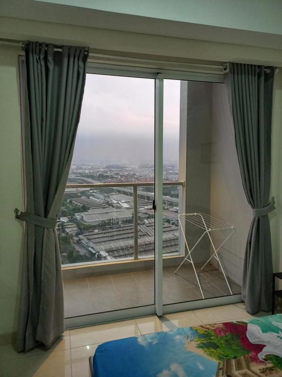 a room with a large window with a view at Sedayu City Apartment Studio Tower Melbourne in Jakarta