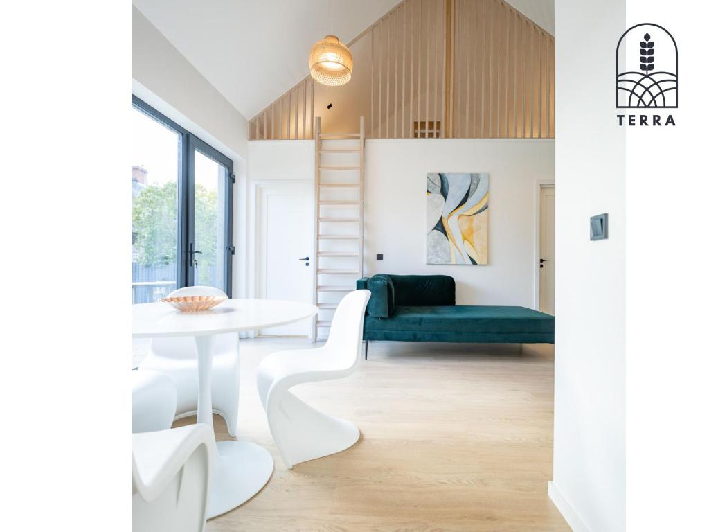 a living room with a white table and a green couch at Terra House in Ventspils