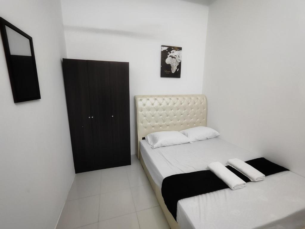 a bedroom with two beds and a black cabinet at Homestay Temerloh Near Hospital Wi-Fi Netflix in Temerloh