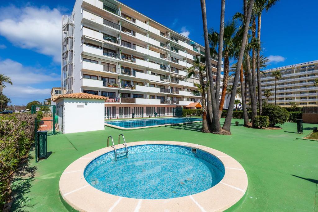 a swimming pool in front of a large building at Apartamento Vista Mar in Alcudia