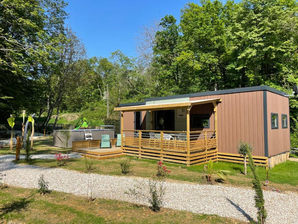 une petite maison dans une cour avec des arbres dans l'établissement Vinéa Cottages - Hébergements Touristiques, Terrasse et Piscine privative, à Bourré
