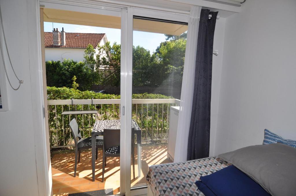 eine Glasschiebetür zu einem Balkon mit einem Tisch in der Unterkunft charmant studio plage et marché à pied in Pornichet