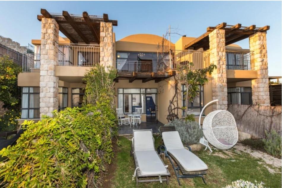 a house with a patio with chaises in the yard at קאמי מלון בוטיק עם ממ"ד - Kami Boutique Hotel in Safed