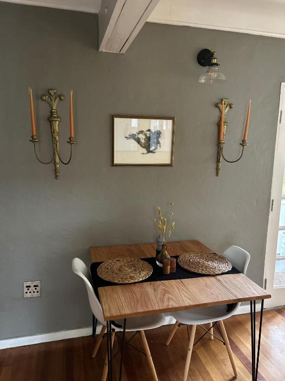 a dining room with a wooden table and chairs at Battiss Guest House in Pretoria