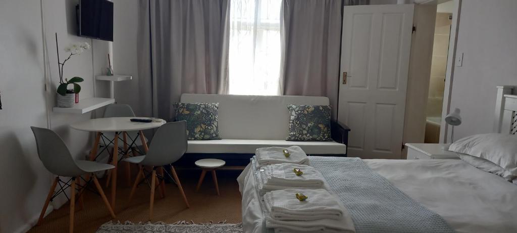 a bedroom with a bed and a table and chairs at Innes Road Durban Accommodation Private Double Room with Private Bathroom in Durban