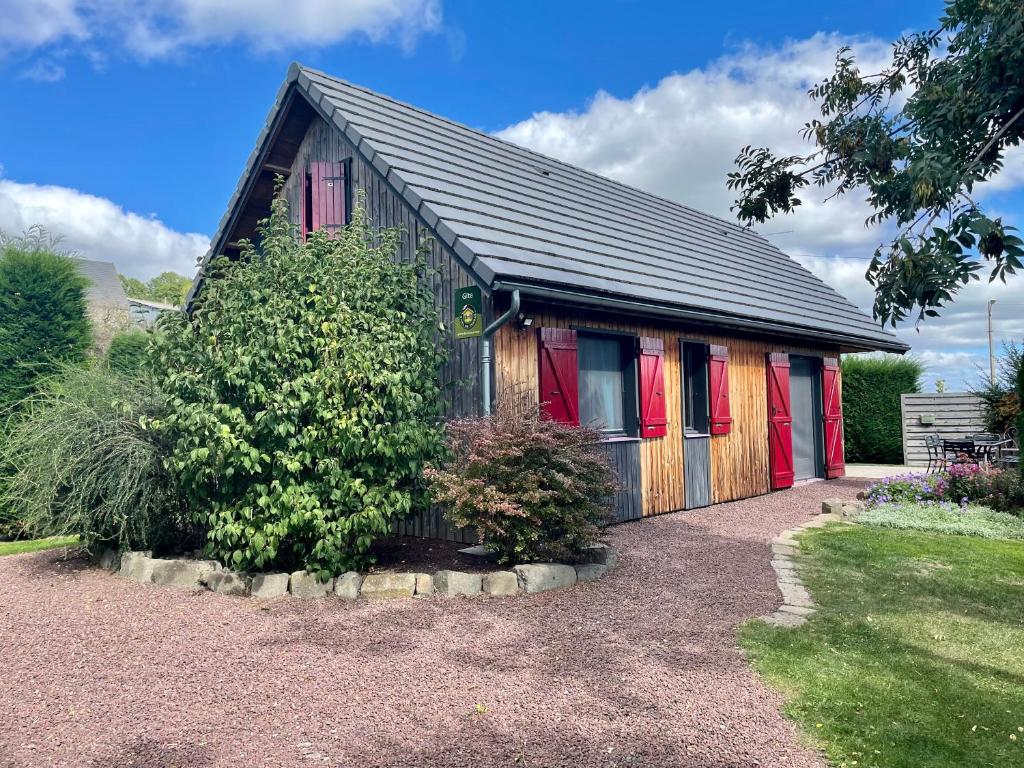 a small house with red doors and a yard at Le loti des Arnats in Saint-Nectaire