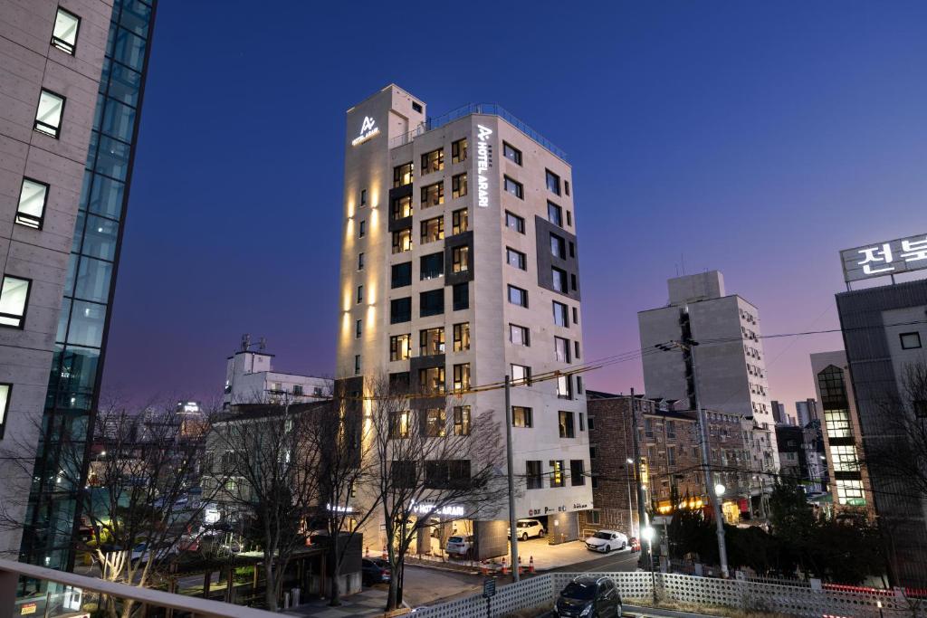 a tall white building in a city at night at Hotel Arari in Jeonju