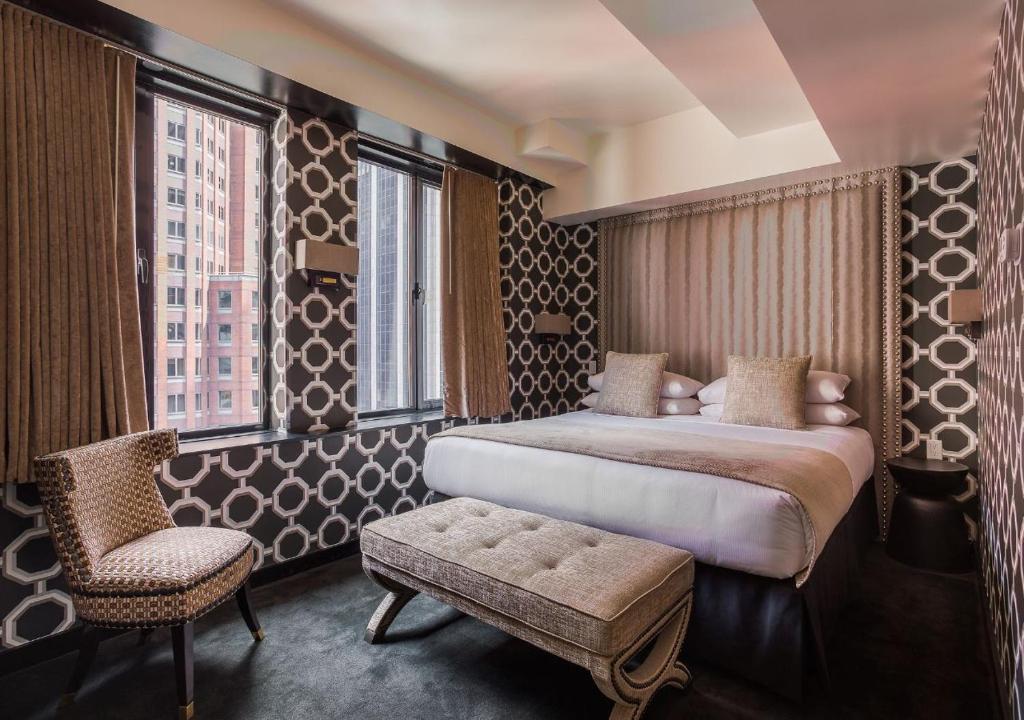a hotel room with a bed and a chair at 45 Times Square Hotel in New York